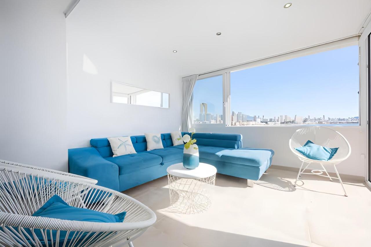 Salón con sofá turquesa y ventanal al mar